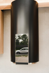 Reflection of the surface of the water heater in silver black. A fuzzy, blurry photo of a reflection on the column surface. Fake column in the kitchen interior