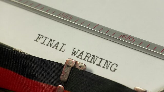 Typing Final Warning on an old manual typewriter. Part of the disciplinary process in an organisation.