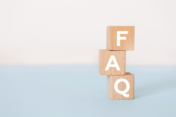 FAQ concept on wooden cubes on the blue background