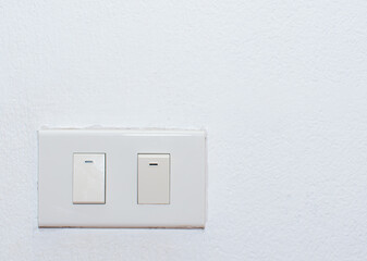 Wall-mounted light switch embedded in concrete wall. Electrical equipment embedded in the wall for turning on the light.