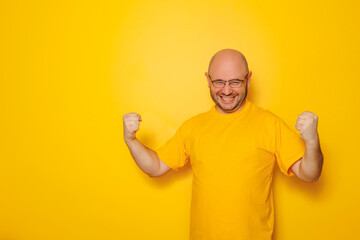 Man celebrating and cheering on yellow color background
