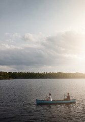 Enjoying the scenery one row at a time. a young couple rowing a boat out on the lake.
