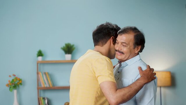 Grateful Indian adult son hugging his senior father at home - concept of emotional support, unconditional love and bonding