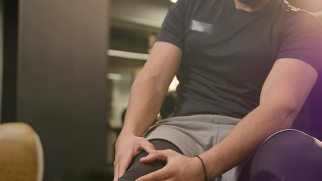 Suffering sick ill unwell unhealthy African American sporty man feel knee muscle pain sportsman athlete male injuring leg in training workout painful trauma injury fitness sport gym ache cramp damage