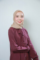 Fototapeta premium Smiling young Asian Muslim woman feels confident and joyful isolated over white background