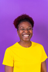 Young african american woman isolated on a purple background smiling and laughing, studio shoot
