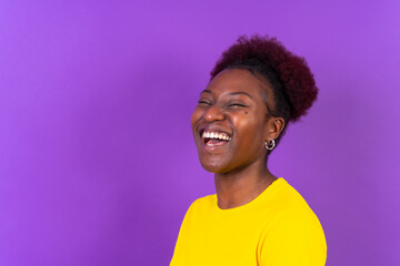 Obraz na płótnie Canvas Young african american woman isolated on a purple background smiling and laughing, studio shoot