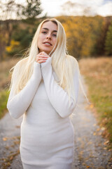 Obraz premium beautiful woman with white dress and black boots in a fall scene outdoor