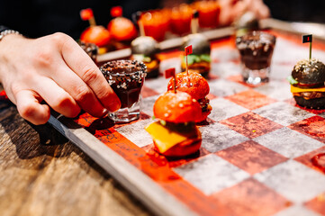 Drunken checkers. men play checkers with shot alcoholic drinks and mini burgers