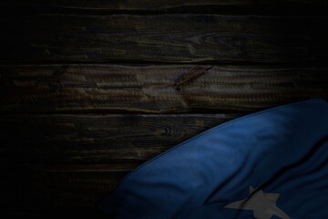 beautiful dark photo of Somalia flag with big folds on old wood with free place for your text - any occasion flag 3d illustration..