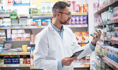 The pharmaceutical pro himself. a mature pharmacist doing inventory in a pharmacy.