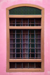 The pink color cement wall with old window, living house architecture detail.