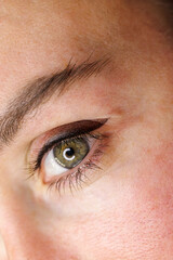 Open eye after tattoo procedure. Permanent make-up of the eyelids, eyelash tattooing.