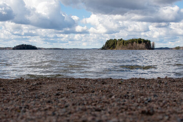 Saunasaari island in lake Pyhäjärvi in Tampere, Finland photographed from Tahmela beach during a partly cloudy day