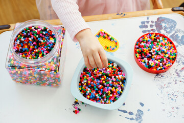 Close-up Portrait of a 3-Year-Old Girl Playing with Hama Beads
