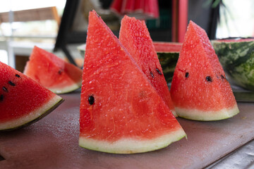 Red Watermelon slice on wooden chopping board with blur background focus.Close-up.