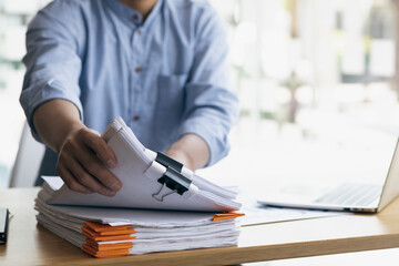 Business Documents, Auditor businessman checking working in stack of paper files for searching...