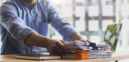 Business Documents, Auditor businessman checking working in stack of paper files for searching...