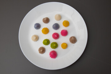 A-Lua dessert which have pink , green, yellow , brown , white in white plate and grey background with blur background focus.Beautiful thailand sweet made from flour and sugar and coconut milk.