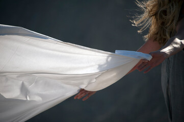 Woman with long blowing white sheet. - 599275153