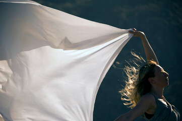 Woman with long blowing white sheet.