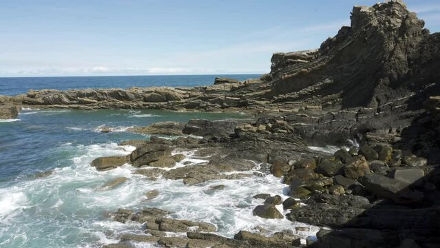 Strange rock formations in northern Spain in the Cantabrian Sea with breaking sea waves.