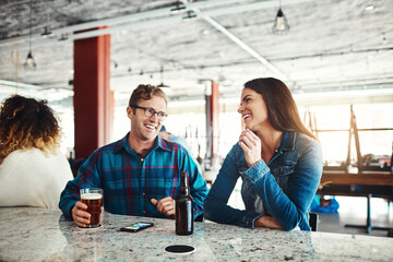 Fototapeta premium What a great way to start the weekend. a couple enjoying a drink at a bar.