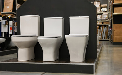 A showcase with new toilet bowls in a supermarket of building materials.
