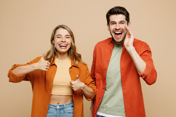 Young couple two friends family man woman wear casual clothes scream share hot news about sales discount hands near mouth together show thumb up isolated on pastel plain light beige color background