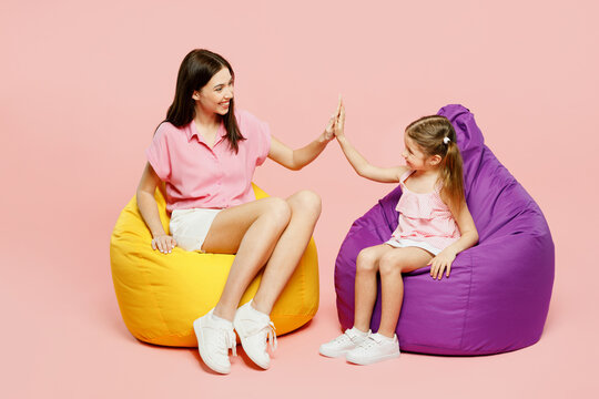 Full Body Woman Wear Casual Clothes With Child Kid Girl 6-7 Years Old. Mother Daughter Sit In Bag Chair Give High Five Clapping Hand Folded Isolated On Plain Pink Background Family Parent Day Concept