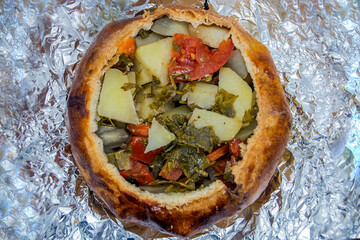 Open pie with fried vegetables and chicken inside
