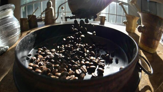 Coffee Beans poured into roasting pan in slow motion in a wide shot