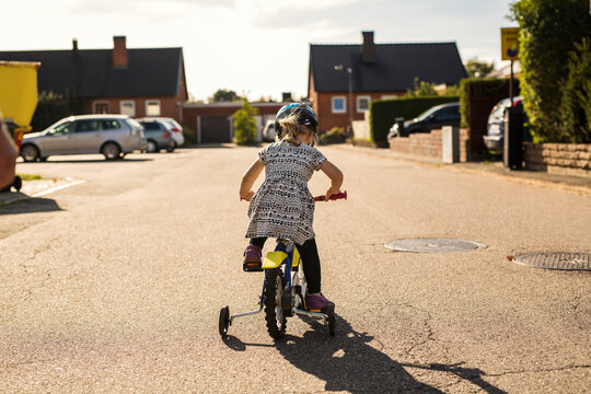 Girl (2-3) riding bicycle on street