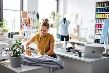 Young fashion designer working at her workplace
