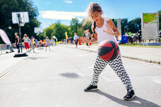 Girl (6-7) dribbling basketball
