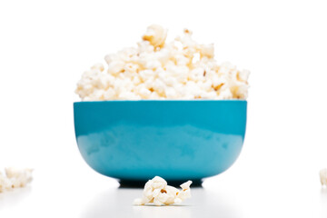 blue bowl with popcorn against white background