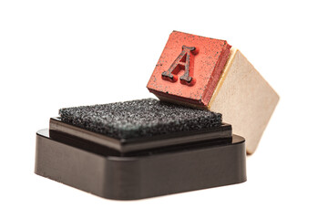 Letter A. Rubber stamp with wooden handle on black ink cartridge.
