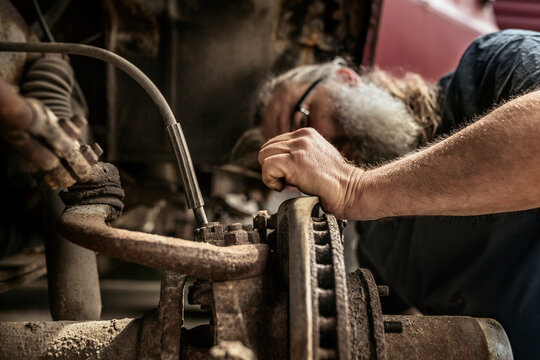Mature man repairing car