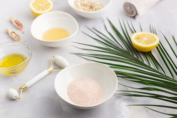 Cosmetic products home spa - Jade roller, towel, olive oil, lemon, oat flakes, tropical leaves, sea salt. 