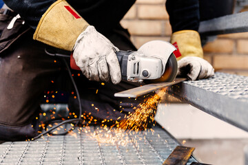 Men cutting metal with grinder