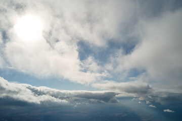 Aerial view from airplane window at high altitude of earth covered with puffy cumulus clouds...