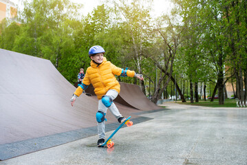 a child rides a blue city cruiser, a plastic bright skateboard, in a skate park on a halfpipe	