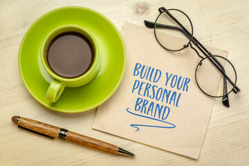 Build your personal brand motivational advice - handwriting on a napkin with a cup of coffee,...