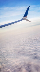 Sky view from inside of a plane, looking at the wing.