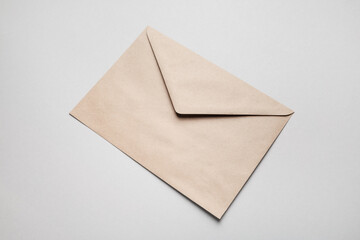 Photo of blank kraft paper envelope on gray paper background.