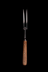 Meat fork isolated on black background.