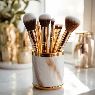 Professional luxurious gold makeup bruses in golden marble holder on marble table in luxury bathroom 