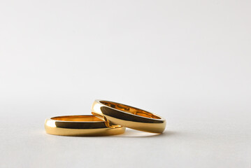 Gold wedding rings lying on white isolated background