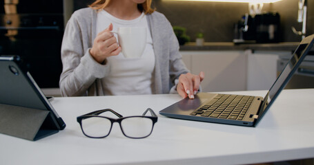 Close Up. Female hands of business woman working on laptop at home with a cup of coffee. Online with computer application technology concept.