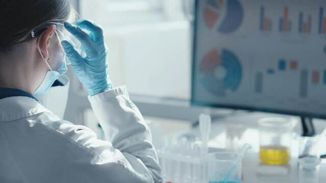 A researcher at a chemical medical laboratory puts on goggles and proceeds to experimental studies with soil and water samples to determine their ecological state and the presence of contaminants.